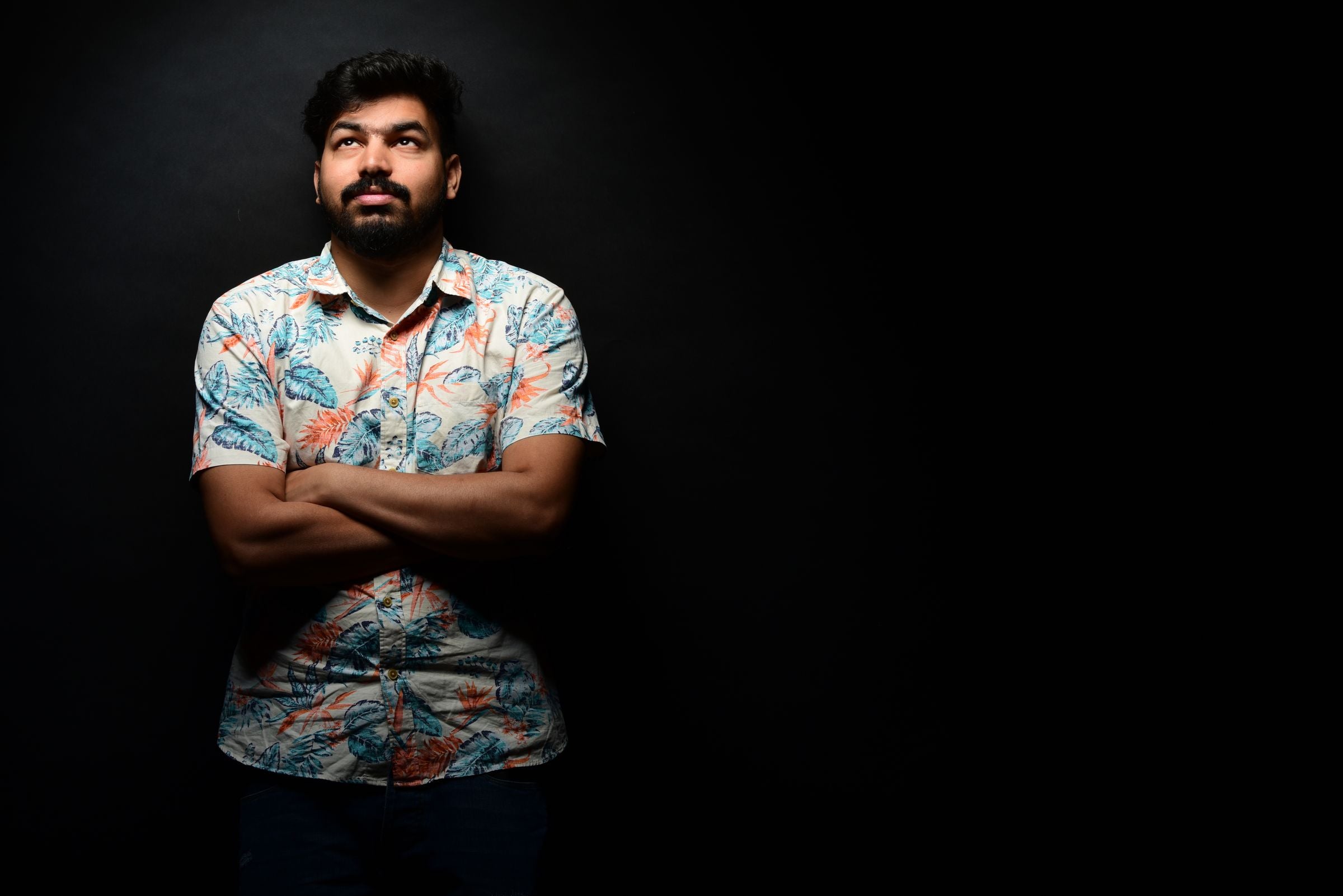 Darkhill — Printed shirt emerging from black bg, dramatic side light — statement-shirt hero