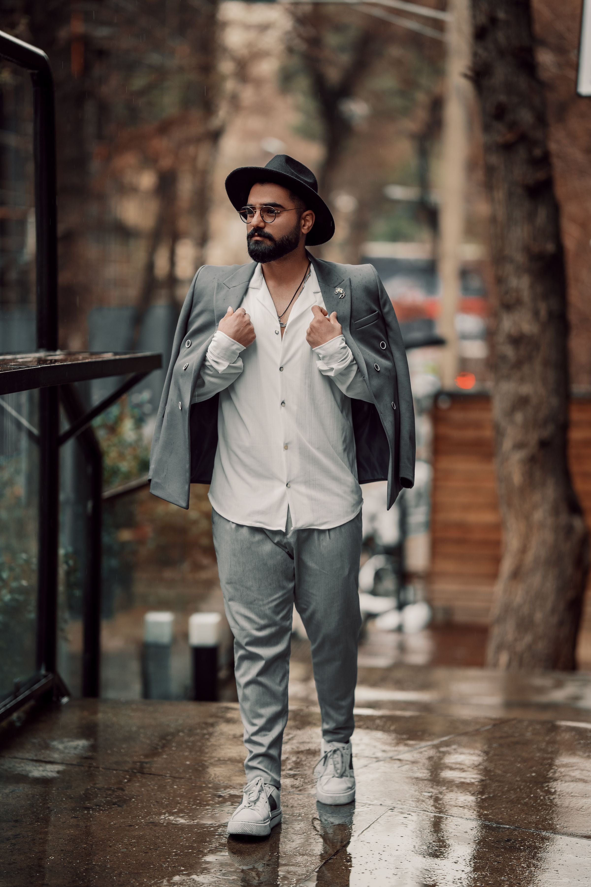 Darkhill — White shirt + draped grey blazer + hat on rainy street — moody finish