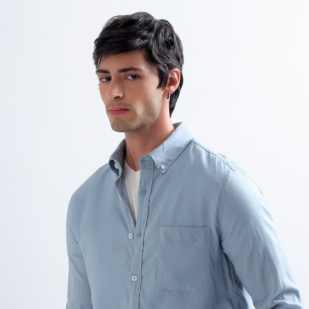 Man in a faded blue Darkhill button-down shirt